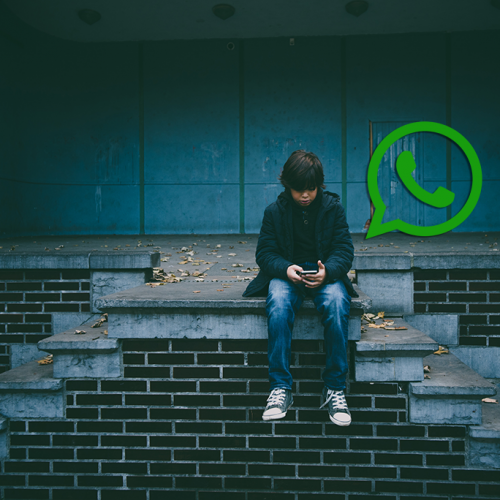 Child sitting on steps using smartphone with whatsapp logo above them