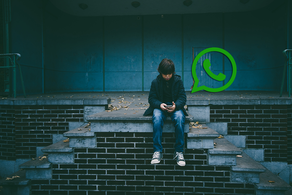 Child sitting on steps using smartphone with whatsapp logo above them