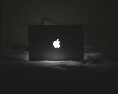 laptop on a bed in a dark room