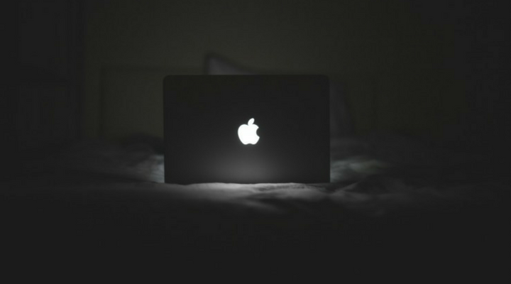 laptop on a bed in a dark room