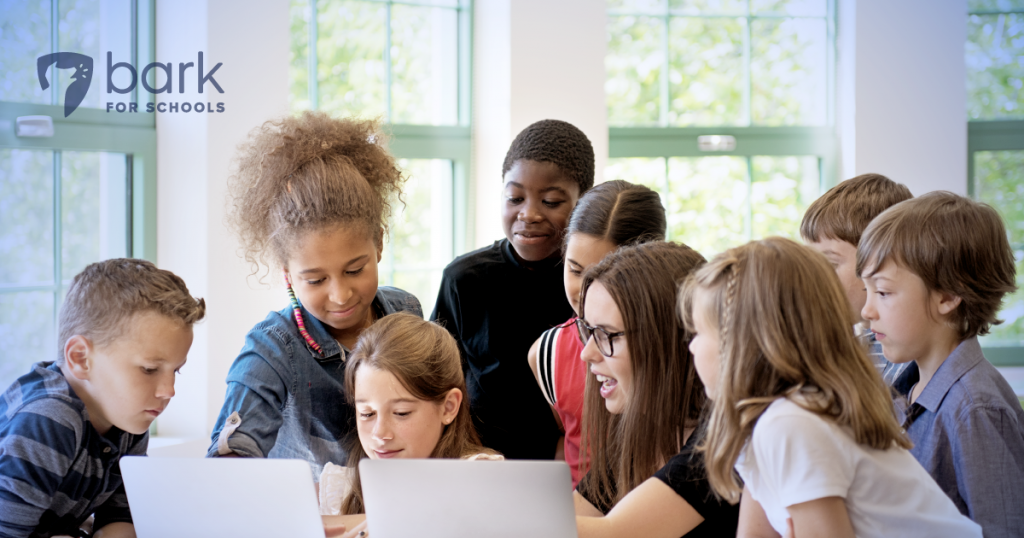 Kids circled around a laptop