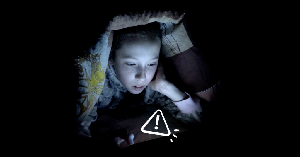 Screen time and sleep header image -- child holding phone in the dark