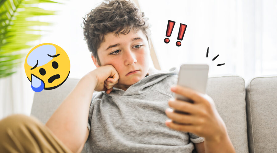 teen boy looking at phone with sad expression