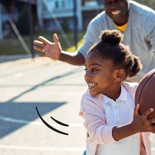 father and daughter playing basketball