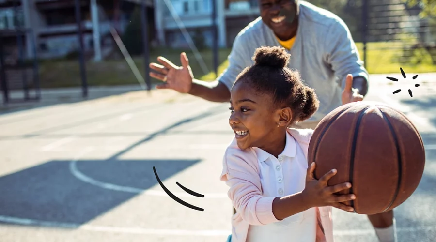 father and daughter playing basketball