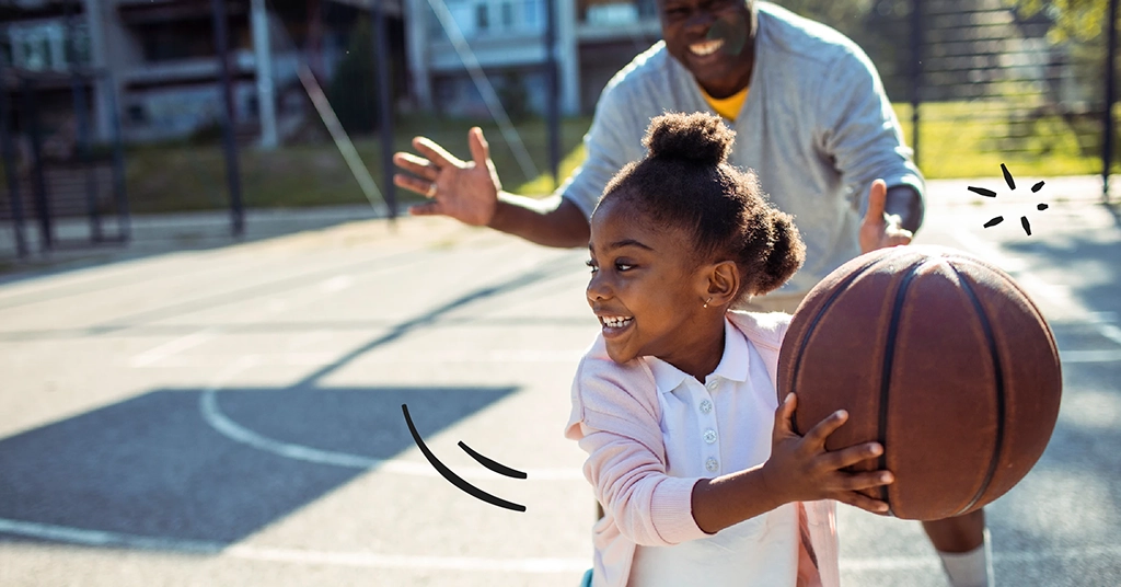 father and daughter playing basketball