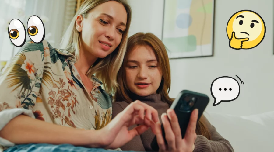 Mom and daughter looking at a phone together with emojis around them