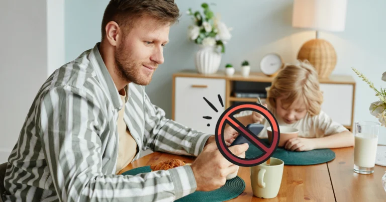 father on his phone at the breakfast table