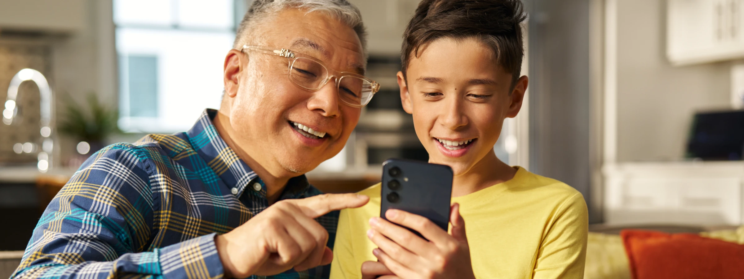 A grandparent and child looking at the Bark Phone together