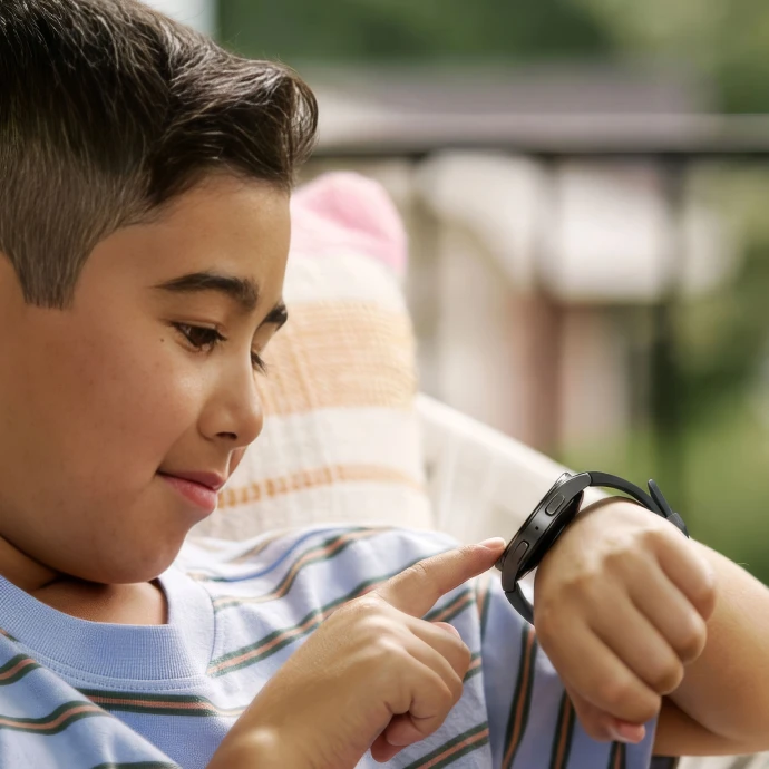 A boy on a porch chair tapping his Bark Watch
