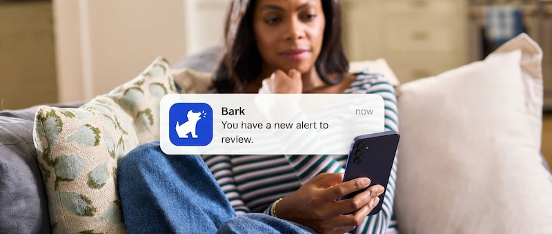 A parent receiving a Bark alert on her phone