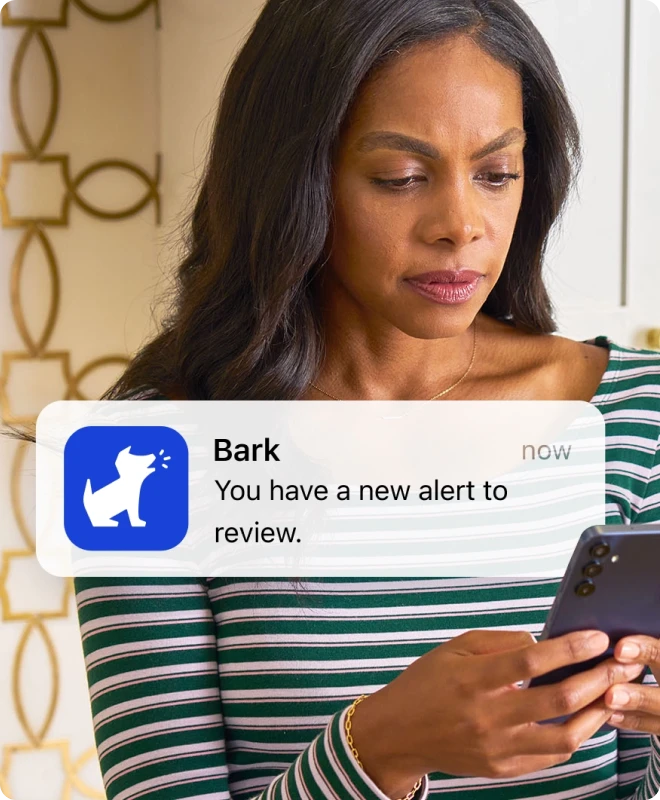 A parent receiving a Bark notification while cooking
