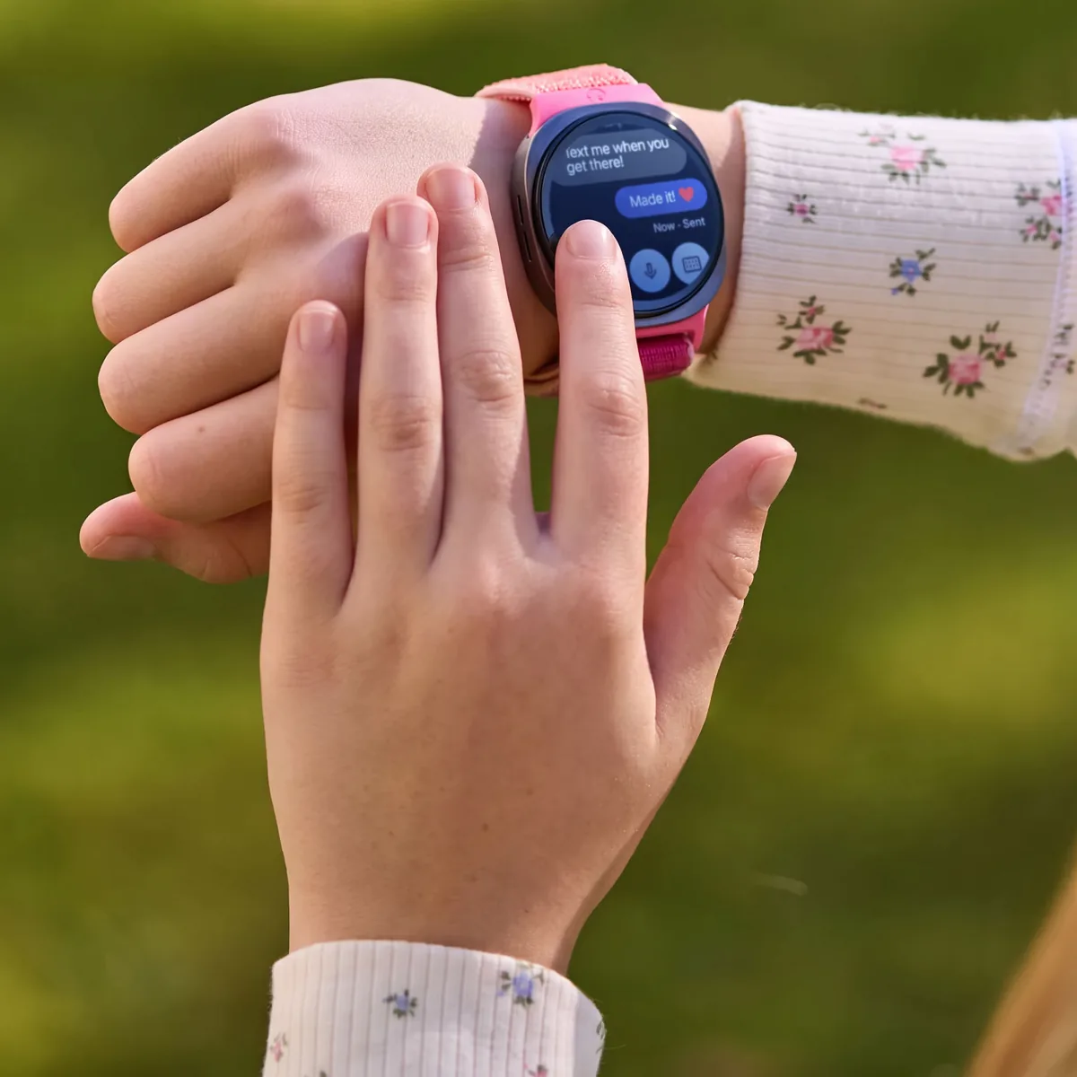 A girl outdoors using her Bark Watch, a kids smartwatch, to text a parent ‘Made it!’