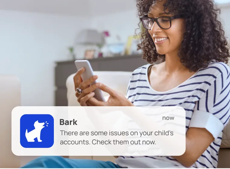 Mom reading a Bark alert on her phone