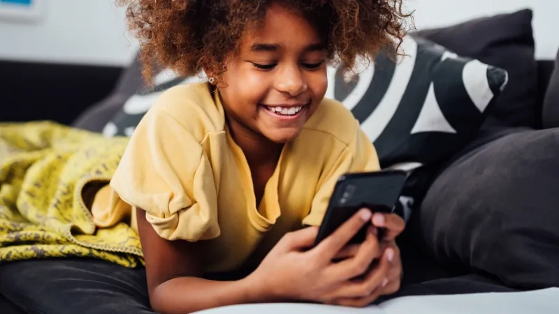 Girl lying on a bed looking at her phone